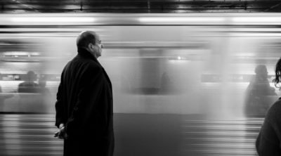 balding man at a train station thinking about hair restoration for men